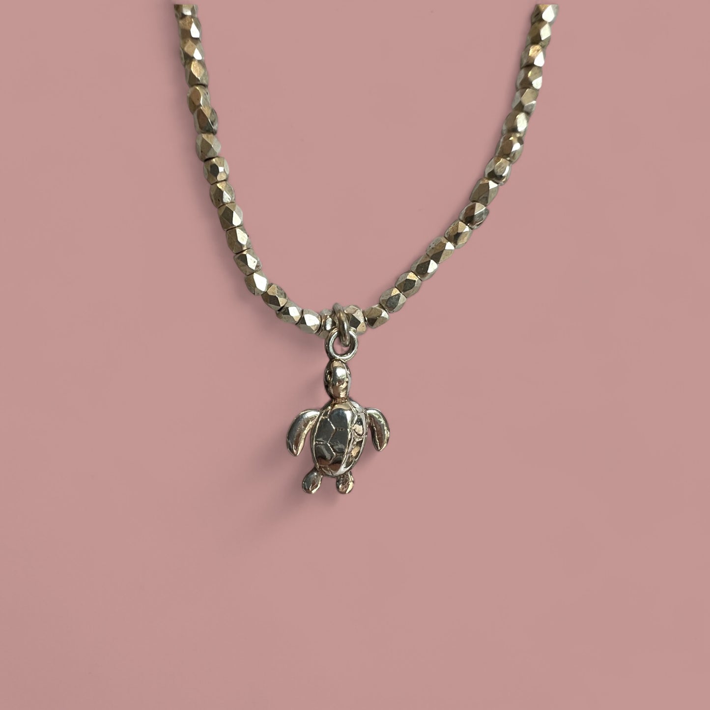 Mes bijoux cajoux présente son petit collier en facettes de bohème, couleur argent, et ça breloque tortue en argent sterling